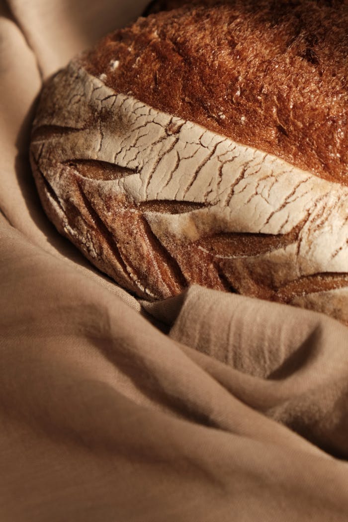 A loaf of bread on a cloth with a brown background